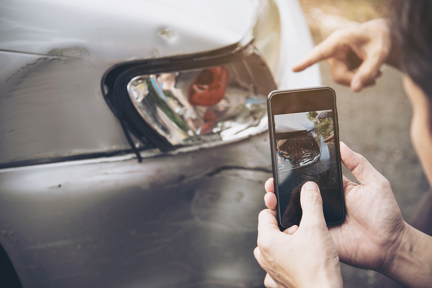 person taking photos of car crash